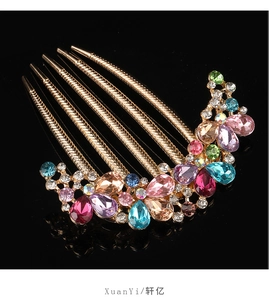 Close-up of vintage gold hair comb with colorful rhinestones on black reflection