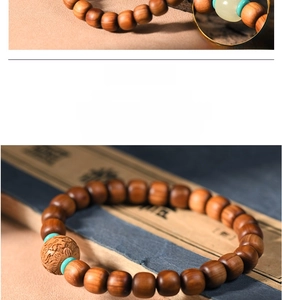 Detailed view of polished Thuja wood beads with carved accent and turquoise spacer