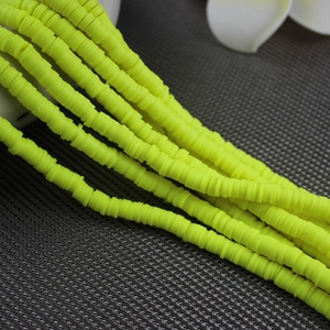 Macro shot of yellow clay disc spacer beads for DIY jewelry bracelet crafting