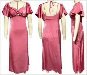 Dettaglio di un abito lungo in raso rosa con scollo a V e elegante schiena scoperta