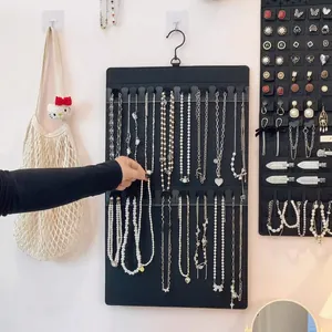 Wall-mounted black felt jewelry organizer with hooks for necklaces and earrings