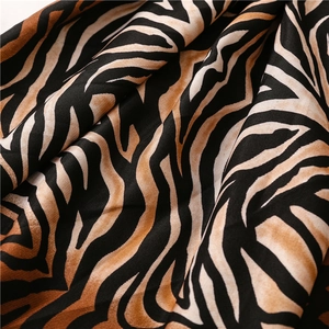 Macro detail of zebra print fabric with orange gradients and woven texture for beach shawls