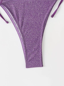Détail du bas de bikini violet scintillant avec liens latéraux et texture brillante