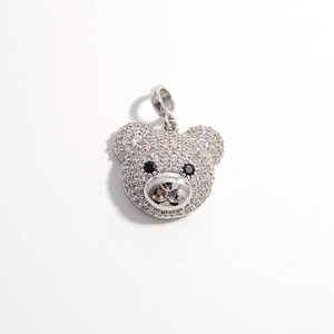 Macro shot of silver teddy bear pendant with sparkling white and black zircon stones