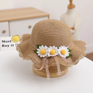 Close-up of khaki woven straw hat featuring delicate white daisies and pink mesh ribbon