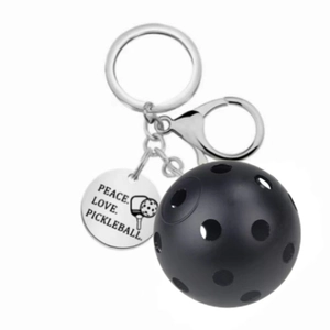Pickleball keychain featuring black plastic paddle ball and engraved stainless steel charm