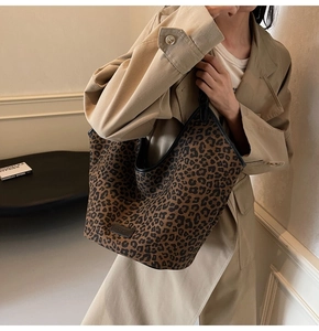 Lifestyle view of large leopard print canvas tote bag carried by a model in a trench coat