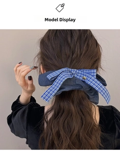 Close-up of oversized denim and blue checkered bow hair tie with a gold metal button
