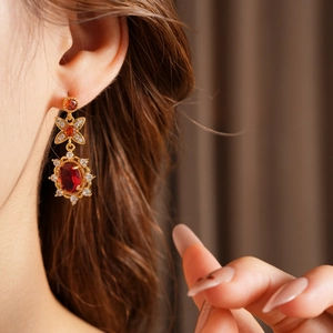 Nahaufnahme goldener Vintage-Ohrringe mit roten Steinen, eleganter höfischer Stil