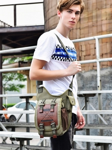 Men's army green canvas messenger bag in vintage military style worn by model outdoors