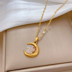 Close-up of gold moon and white rabbit pendant on a dainty titanium steel chain