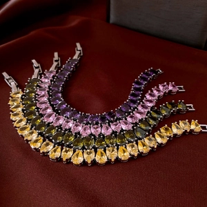 Detail of tear-drop zircon bracelets in four colors on luxury red satin background