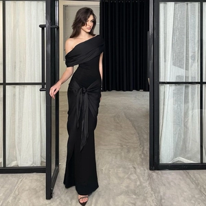 Detail view of black off-shoulder evening dress with a large decorative waist bow