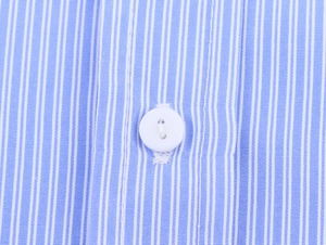 Dettaglio del tessuto a righe blu e bianche con bottone bianco di alta qualità