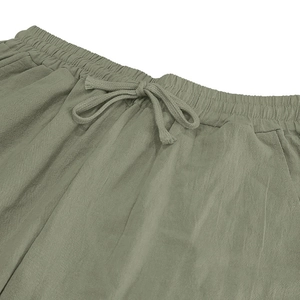 Detail of sage green linen pants featuring elastic waistband and adjustable drawstring tie