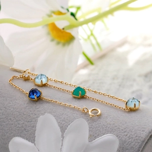 Macro shot of S925 silver gold-plated bracelet with green chalcedony and white shell