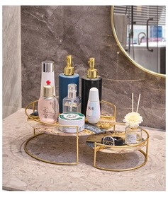 Detalle de estante de baño dorado con textura de mármol y organizador de cosméticos