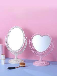 Detail of vintage heart-shaped and oval desktop mirrors with floral embossed frames