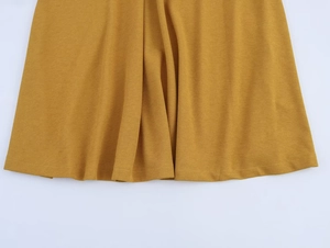Dettaglio del vestito giallo senape con scollo all'americana e tessuto con texture