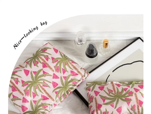 Detailansicht der rosa Make-up-Tasche mit Palmenmuster neben einem Parfümflakon