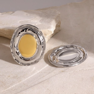Detail view of two-tone oval earrings with gold heart and silver border on stone