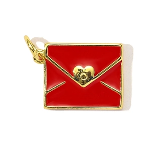 Macro view of gold-plated red enamel envelope pendant with heart detail and jump ring