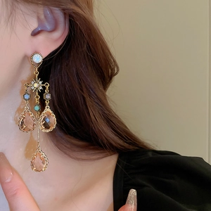 Vintage golden drop tassel earrings with champagne crystals worn by a model in profile
