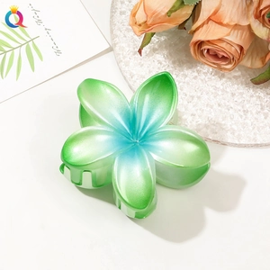 Close-up of green-blue gradient flower hair claw with pearlescent finish and resin petals