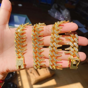 Detail of gold Cuban link bracelets with iced-out thorny links and secure clasp