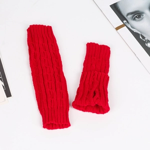 Close-up of red cable knit arm warmers made of soft acrylic yarn in a stylish flat lay