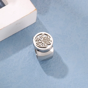 Macro detail of silver Hamsa Hand ring with hollow design and center diamond on blue texture