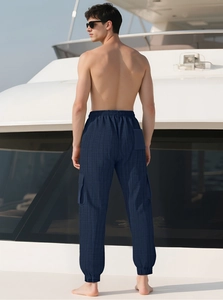 Détail d'un pantalon cargo homme bleu marine à carreaux avec cordon et ourlet sur un bateau