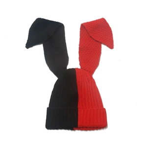 Detailed view of red and black split-color knit beanie with long floppy bunny ears