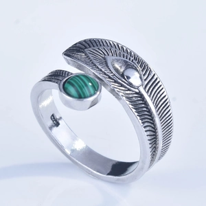 Close-up of feather-shaped adjustable silver ring featuring a green malachite gemstone