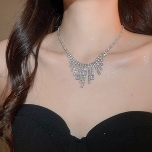 Close-up of sparkling square zircon tassel necklace worn by a model in luxury style