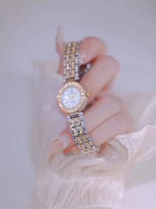Close-up of a silver and gold two-tone ladies' watch with rhinestones on a wrist