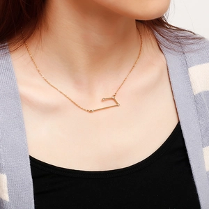 Close-up of a gold stainless steel zodiac pendant necklace with sparkling crystal inlay