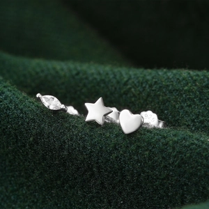 Macro detail of S925 sterling silver set featuring heart, star, and zircon stud earrings