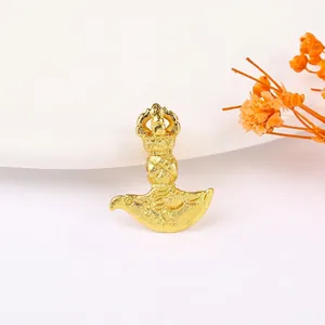 Macro detail of golden Kartika Buddhist pendant with intricate frosted carvings