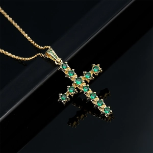 Collier croix élégant plaqué or 18K avec zircons vert émeraude sur fond noir brillant