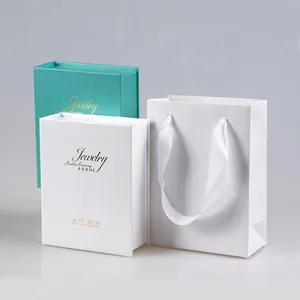 Book-style jewelry gift boxes in white and green with a matching paper shopping bag