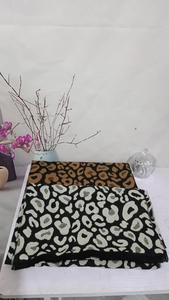 Detailed view of leopard print scarves in brown and white with soft fringe edges