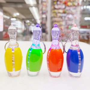 Close-up of bowling pin LED keychains in yellow, green, orange, and blue plastic