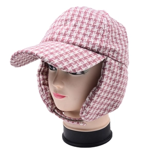 Detail of pink and white houndstooth earflap hat with warm lining and adjustable straps