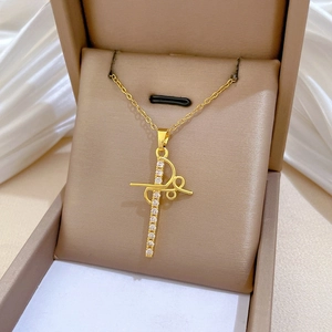 Detail shot of a gold cross pendant necklace with sparkling zircons in a jewelry box