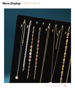 Detail view of gold necklaces and zircon bracelets on a black velvet jewelry display stand