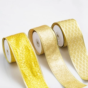 Three rolls of gold Christmas ribbon with glitter textures and wired edges for holiday decor