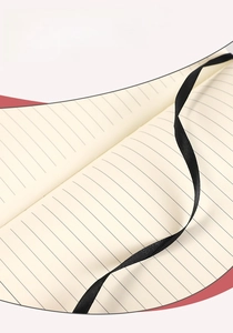 Macro detail of creamy lined paper and elegant black silk ribbon bookmark in notebook
