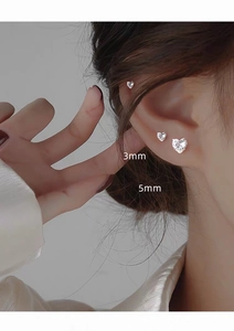 Detail showing 3mm and 5mm heart-shaped zircon silver studs worn on a model's ear