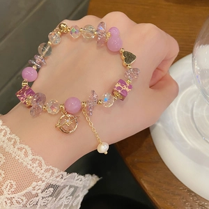 Detailaufnahme von violettem Amethyst-Perlenarmband mit Planetenanhänger und Herz